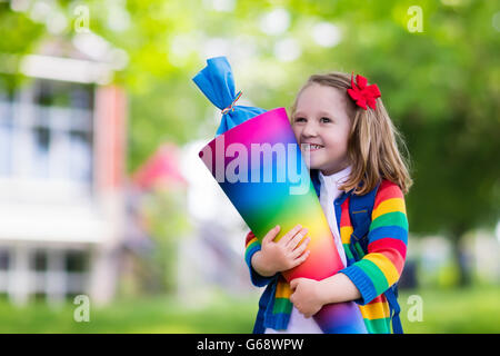 Glückliches Kind mit traditionellen deutschen Süßigkeiten Kegel am ersten Schultag. Kleine Schüler mit Büchern begeistert zurück in der Schule sein. Stockfoto