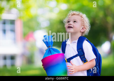 Glückliches Kind mit traditionellen deutschen Süßigkeiten Kegel am ersten Schultag. Kleine Schüler mit Büchern begeistert zurück in der Schule sein. Stockfoto