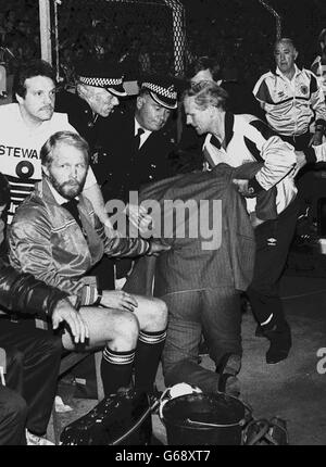 Schottlands legendärer Fußballmanager Jock Stein wird nach dem Zusammenbruch und dem Sterben geholfen, als die letzte Pfeife über das entscheidende WM-Spiel seines Teams mit Wales im Ninian Park hinwegging. Die Teams zogen 1:1. Stockfoto