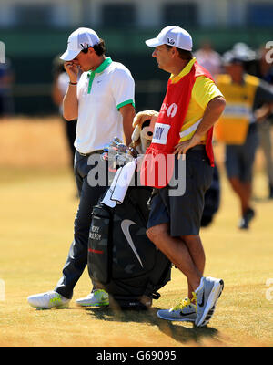 Der nordirische Rory McIlroy sieht mit seinem Caddy JP Fitzgerald am ersten Tag der Open Championship 2013 im Muirfield Golf Club, East Lothian, niedergeschlagen aus. Stockfoto