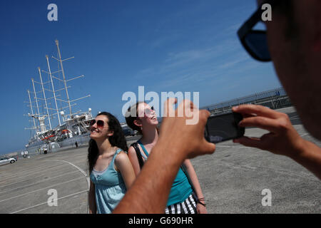 Zwei Frauen lassen sich vor dem Wind Surf, Dun Laoghaire Harbour, Dublin, fotografieren. Stockfoto