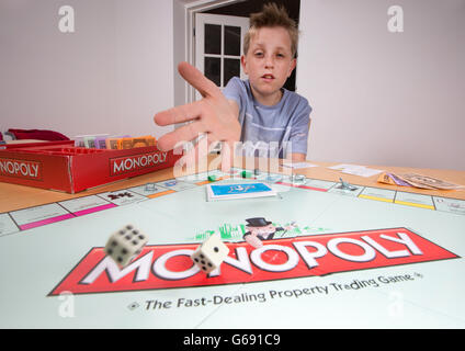 Ein Junge spielt das Brettspiel Monopoly Stockfoto