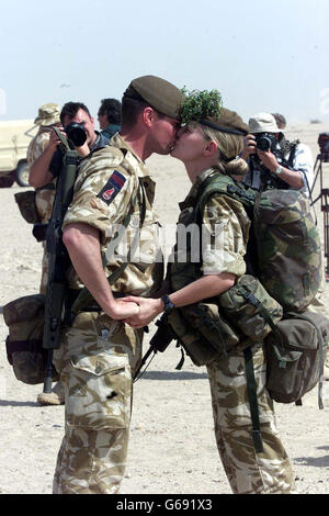 Michelle Ullyott und Gavin O'Neill von der irischen Garde teilen sich nach der Parade am St. Patrick's Day in Kuwait einen Kuss. Stockfoto