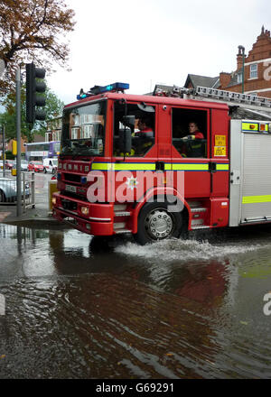 Notfallfeuerwehren reagieren auf die Szene an der stark überfluteten Kreuzung zwischen Mansfield Road und Hucknall Road in Nottingham, als eine plötzliche Sturzflut ein Straßenlokal mit Regenwasser überflutet verließ. Stockfoto