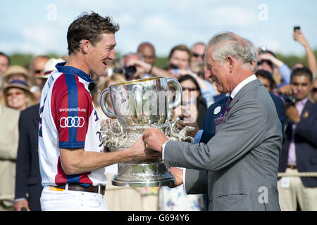 Der Prinz von Wales überreicht dem englischen Kapitän Luke Tomlinson im Guards Polo Club in Egham, Surrey, die Siegertrophäe Audi International Polo mit dem Westchester Cup. Stockfoto