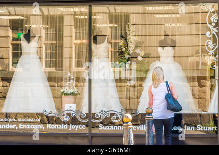 Eine Frau auf der Suche in einem Brautmodengeschäft Fenster Stockfoto