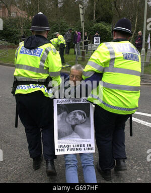 Ein Anti-Kriegs-Protestler, der von der Polizei während eines Sitzprotest vor das Ständige Hauptquartier der britischen Streitkräfte in Northwood, im Nordwesten Londons, geschleppt wird. Stockfoto