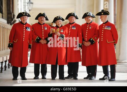 Chelsea Rentner feiern die Geburt des Sohnes des Herzogs und der Herzogin von Cambridge im Royal Chelsea Hospital in London, indem sie dem Königspaar einen kleinen Teddybär des Royal Hospital in traditioneller scharlachroten Uniform anrösten und schicken. Stockfoto