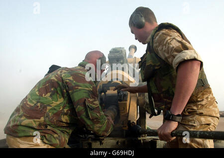 Britische Soldaten des 29 Commando Regiment Royal Artillery laden 105 mm Schuss zurück, um Ziele in Abu al Khasib, einer irakischen Militärhochburg außerhalb der Stadt Basra im Südirak zur Unterstützung eines Angriffs der britischen Royal Marines auf das Gebiet, zu erschießen. Stockfoto