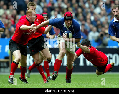 Der französische Kapitän Fabian Pelous kommt während des RBS 6 Nations Championship-Spiels im Stade de France von den Tackles von Martyn Williams (links) und Iestyn Harris (rechts) aus Wales weg. Stockfoto