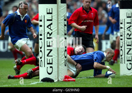 Frederic Michalak schlägt das Tackle des walisischen Stephen Jones und erzielt beim Sieg beim RBS 6 Nations Championship-Spiel im Stade de France, Paris, den dritten Versuch Frankreichs. Stockfoto