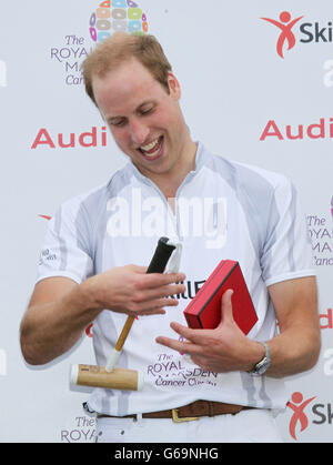 Der Duke of Cambridge lächelt, als er ein Kinderpolo mallett nach einem Charity-Polo-Spiel bei der Audi Polo Challenge im Coworth Park, Berkshire, überreichte. Stockfoto