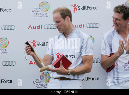 Der Duke of Cambridge lächelt, als er ein Kinderpolo mallett nach einem Charity-Polo-Spiel bei der Audi Polo Challenge im Coworth Park, Berkshire, überreichte. Stockfoto