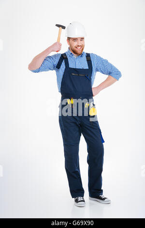 Lächelnd lustige junge Baumeister Anwendung Hummer an den Kopf im Helm und Spaß Stockfoto
