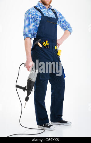 Bärtiger junger Mann im gesamten Betrieb Bohren Stockfoto