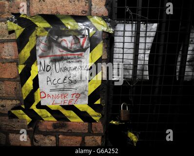 Ein provisorisches Warnschild neben dem verschlossenen Tor, das zu den Bahnsteigen der ehemaligen U-Bahnstation Brompton Road führt, eine stillstehende Station auf der Piccadilly-Linie zwischen South Kensington und Knightsbridge, die sich im Besitz des Verteidigungsministeriums befindet und auf dem Immobilienmarkt steht. Stockfoto