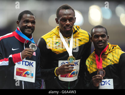 Jamaikas Usain Bolt mit seiner Goldmedaille neben dem Silbermedaillengewinner, dem US-amerikanischen Justin Gatlin (links) und der Bronzemedaillengewinnerin Nesta Carter (rechts) am dritten Tag der IAAF-Leichtathletik-Weltmeisterschaften 2013 im Luzhniki-Stadion in Moskau, Russland. Stockfoto