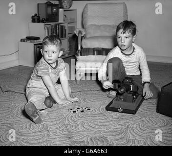 1940S 1950S STOCK ZWEI JUNGS SITZEN IM WOHNZIMMER ANZEIGEN FOLIEN MIT DIA-PROJEKTOR Stockfoto