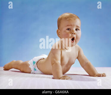 1960ER JAHRE BABY MIT LUSTIGEN GESICHTSAUSDRUCK TUN PUSHUP Stockfoto