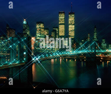 1980ER JAHRE LOWER MANHATTAN SKYLINE BEI NACHT ZEIGT WORLD TRADE CENTER TÜRME PRE-911 UND BROOKLYN BRÜCKE LEUCHTET IN NEW YORK CITY-NY-USA Stockfoto