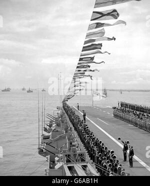 Die Besatzung des australischen Flugzeugträgers Sydney steht auf dem Deck des Schiffes, um die Königin während der Krönung der Marine in Spithead zu bejubeln. Die Queen, an Bord der Royal Yacht, dem Dispatch-Schiff Surprise, übergab die Linien britischer, Commonwealth- und ausländischer Kriegsschiffe. Stockfoto