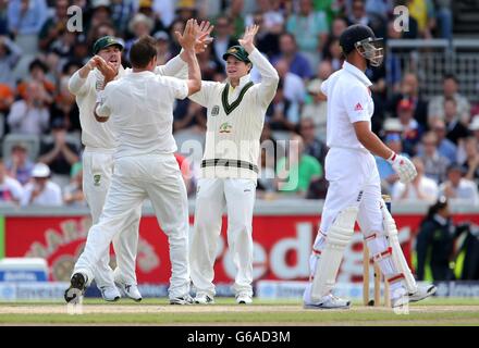 Die Australier Steve Smith und David Warner feiern mit Bowler Ryan Harris, nachdem sie am dritten Tag des dritten Investec Ashes Testmatches im Old Trafford Cricket Ground in Manchester das Wicket des englischen Batsman Jonathan Trott für 5 Stunden genommen haben. Stockfoto