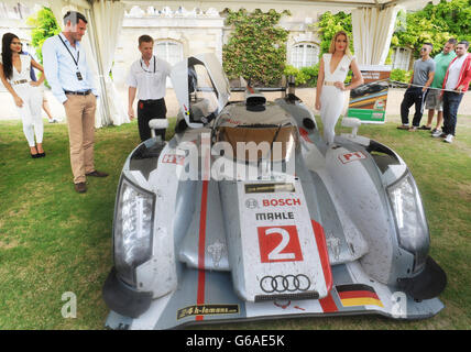 NUR FÜR REDAKTIONELLE ZWECKE: Lord Pembroke (links), Mitbegründer des Wilton Classic und Supercars, wird 2013 von seinem Fahrer Allan McNish (2. Links) Wilton Classic und Supercars mit Castrol EDGE im Wilton House in Salisbury den Audi R18 e-Tron quattro gezeigt. Stockfoto