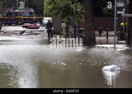 Die Londoner Feuerwehr, die an der Half Moon Lane in Herne Hill, London, teilnimmt, als eine berstende Wasserleitung zu schweren Überschwemmungen mit bis zu einem Meter tiefen Wasser geführt hat Stockfoto