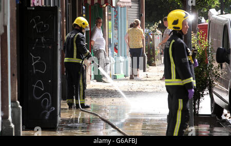 Feuerwehrleute helfen bei der Säuberung nach einer Überschwemmung nach dem Platzen einer Wasserleitung in Herne Hill, South London. Stockfoto