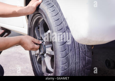 Händen der Mechaniker die Mutter des Autorades holen und anziehen Stockfoto