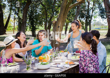 Freunde, die unbeschwerte Mahlzeit im freien zusammen Stockfoto