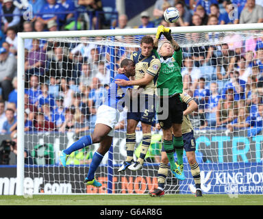 Der Wes Morgan von Leicester City springt mit dem Keeper Paddy Kenny von Leeds United und Jason Pearce für den Ball Stockfoto