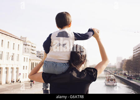 Mutter mit kleinen Jungen auf Schulter, gemeinsam betrachten Stockfoto