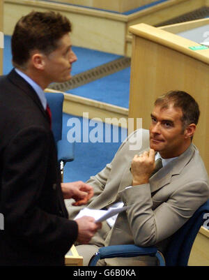 Tommy Sheridan blickt auf Colin Fox, der vorbeigeht, bevor er bei der ersten Sitzung des schottischen parlaments nach den Wahlen in Edinburgh den Treueeid ablegt. Stockfoto