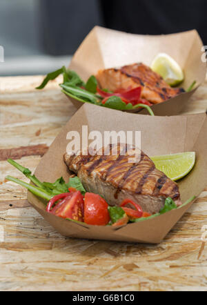 Streetfood Thunfisch und Lachs Steaks serviert mit Gemüse in Karton Teller Nahaufnahme im freien Stockfoto