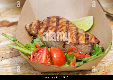 Suppen-Thunfisch-Steak serviert mit Gemüse in Karton Teller Nahaufnahme im freien Stockfoto