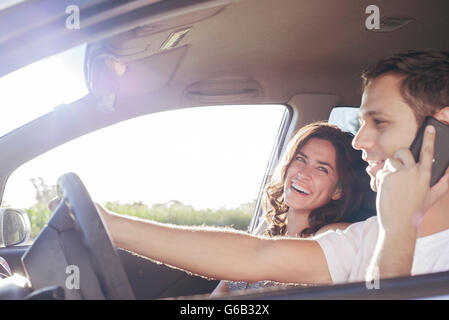 Paar Reiten im Auto zusammen, während die Fahrer plaudert auf Handy ohne Freisprecheinrichtung Stockfoto