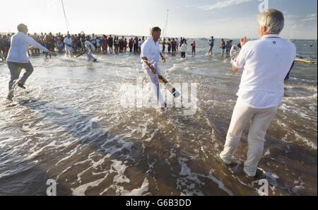 Action während des jährlichen Bramble Bank Cricket-Spiels, das auf einer Sandbank mitten im Solent bei Ebbe im Frühling stattfindet. Stockfoto