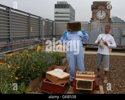 Mark Berry, aka Bez, ehemaliges Mitglied der Manchester-Band The Happy Mondays, rechts, hält einen Künstler als Imker in der Druckerei im Stadtzentrum von Manchester, hält Adrian Rhodes während einer Fotozelle ein Tablett mit Honigbienen in der Schublade. Stockfoto