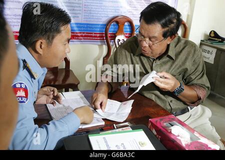 Phnom Penh, Kambodscha. 24. Juni 2016. Cambodian Prime Minister Samdech Techo Hun Sen (R) zahlt eine Geldstrafe, ein Verkehrs-Polizist in Phnom Penh, Kambodscha, 24. Juni 2016. Kambodschanische Premierminister Samdech Techo Hun Sen am Freitag zahlte eine Geldstrafe Verkehrspolizei für nicht das Tragen eines Helmes während seiner Motorradtour letzte Woche in der südwestlichen Provinz Koh Kong. © Phearum/Xinhua/Alamy Live-Nachrichten Stockfoto