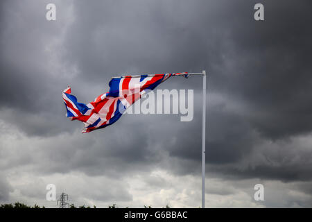 Southport, Merseyside, England. 24. Juni 2016. Großbritannien Wetter: Dunkle stürmischen Wolken über Lancashire. Ein Tag der wenig Sonne und kräftige Schauer, von denen einige schaltet gewittriger, da die Tagestemperaturen beginnt zu steigen, wie eine geschlagene britische Flagge im Wind flattert. Bildnachweis: MediaWorldImages/Alamy Live-Nachrichten Stockfoto