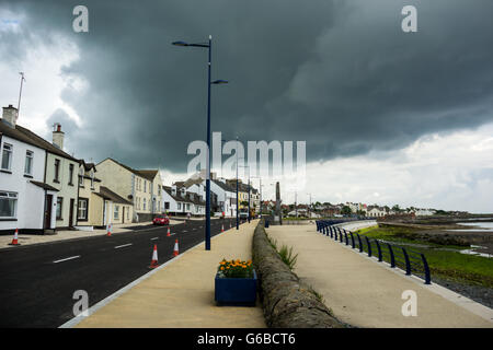 Donaghadee, County Down, UK 24. Juni 2016 Baustellen Verkehr Kegel verhindern Parkplatz mit dunklen grüblerischen Himmel über Reparaturen von Fahrbahnoberflächen als Teil der öffentlichen Investitionen Jeffrey Silber/Alamy Live News Stockfoto