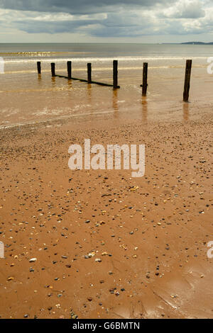 Regenwolken über eine ruhige See und einsamen Strand. Stockfoto