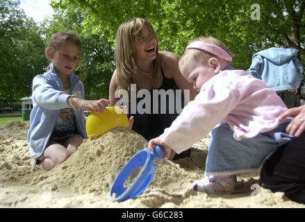 Die BBC-Kindermoderatorin Kate Heavenor spielt mit ehemaligen Patienten des Great Ormond Street Hospital (von links nach rechts) Stella Hyams, sechs, und Katie Bird, 21 Monate im Coram Fields Park im Zentrum von London, während Dutzende von Patienten aus der Vergangenheit und der Gegenwart eine Kinderparty genossen. * aus diesem Anlass jährte sich zum zehnten Mal die größte pädiatrische Intensivstation in Europa im Great Ormond Street Hospital. Stockfoto