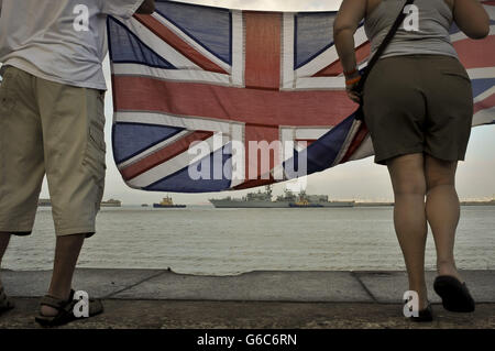 Gibraltarians winken Unionsflaggen, als das Royal Navy-Kriegsschiff HMS Westminster vor den Übungen im Mittelmeer im Hafen von Gibraltar für einen planmäßigen Besuch eintrifft. Stockfoto