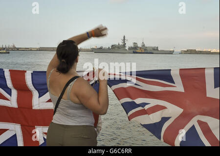 Gibraltarians winken Unionsflaggen, als das Royal Navy-Kriegsschiff HMS Westminster vor den Übungen im Mittelmeer im Hafen von Gibraltar für einen planmäßigen Besuch eintrifft. Stockfoto