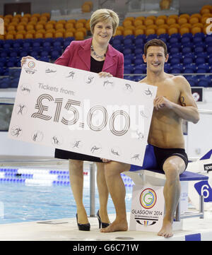 Der olympische Silbermedaillengewinnerer Michael Jamieson und die stellvertretende schottische First Ministerin Nicola Sturgeon markieren den Beginn des Ticketverkaufs für die Commonwealth Games während einer Fotoausstellung im Tollcross International Swimming Center in Glasgow. Stockfoto