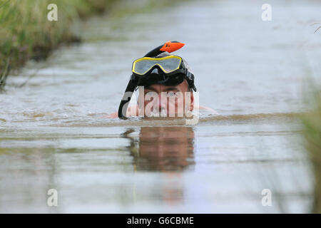 Ein Teilnehmer während der jährlichen World Bog Schnorchel Championship, die jeden August an der Bank Holiday im dichten Waen Rhydd Torfmoor in der Nähe von Llanwrtyd Wells in Mittelwales stattfindet. Stockfoto