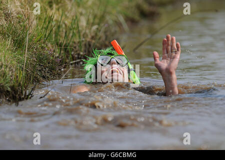 Ein Teilnehmer während der jährlichen World Bog Schnorchel Championship, die jeden August an der Bank Holiday im dichten Waen Rhydd Torfmoor in der Nähe von Llanwrtyd Wells in Mittelwales stattfindet. Stockfoto