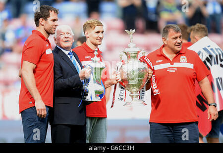 Dave Whelan, Vorsitzender von Wigan Athletic (zweiter links), hält den FA Cup neben dem Rugby-League-Spieler Pat Richards (links) von Wigan Warriors und Sam Tomkins sowie dem Cheftrainer Shaun Wane, der während des Spiels der Sky Bet Football League Championship im DW Stadium, Wigan, den Challenge Cup abhält. Stockfoto